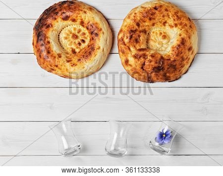 Two Freshly Baked Cake - Tandoor Bread On A White Wooden Background, Next To Glasses Of Armudu For T