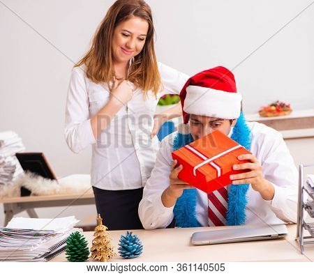 Colleagues exchaing christmas presents in office