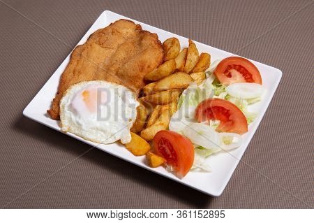 Closeup Of A Combo Platter With Fried Egg, Fried Chicken, French Fries And Salad