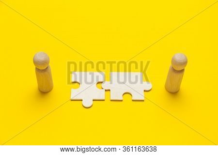 Wooden Figures With Pazzles On Yellow Background. Agreement Between Business Mans, Cooperation And D