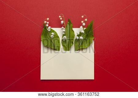 May Fresh Lily Of The Valley In A Mail Envelope On A Red Background. Wedding Invitation Concept, Rom