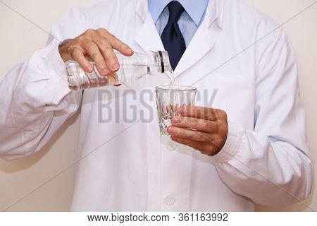 The Doctor Pours A Glass Of Useful Mineral Water For Diet