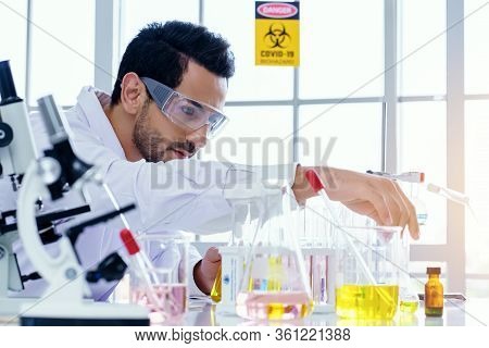 Doctor And Microbiologist With Vacuum Tubes For Samples With Covid-19 Coronavirus Chinese Infection
