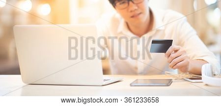 Asian Man Customer Using Credit Card For Online Shopping During Quarantine At Home. Male Shopper Buy