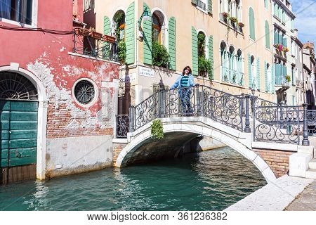 Venice, Italy - September 28, 2015 : Streets Of Venice City. Woman In Blue Jacket Is Standing On A P