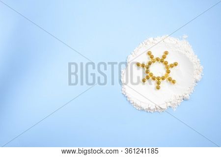 Vitamin D Yellow Pills In The Shape Of Sun On White Lecitin Powder In Sky Blue Background, Nutrition