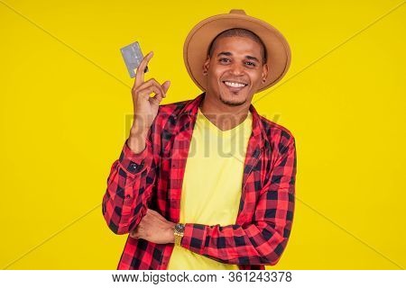 Afro Brazilian Man With Credit Card In Stusio On Yellow Background.farmer Taking A Loan In A Bank Fo