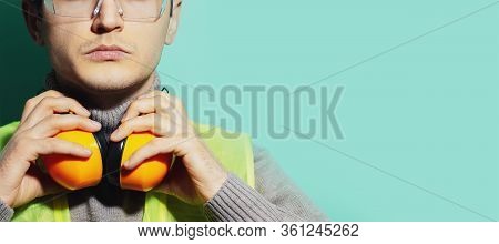 Studio Close-up Portrait Of Young Airport Worker, Engineer Mechanic, Isolated On Background Of Aqua 