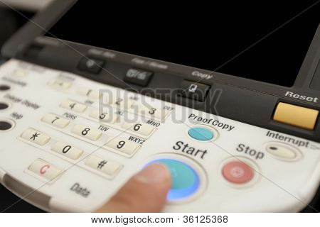 นิ้วกดปุ่มที่แป้นพิมพ์ของเครื่องเลเซอร์