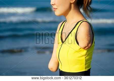 Happy Asian Armless Woman Warming Up Before Swimming At The Tropical Beach