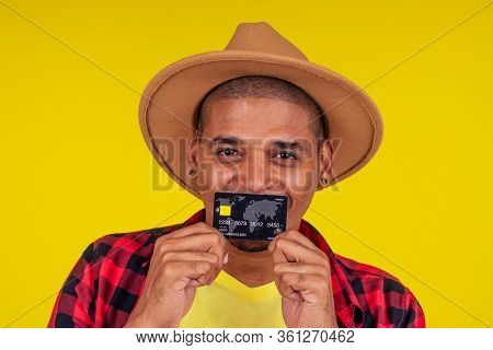 Afro Brazilian Man With Credit Card In Stusio On Yellow Background.farmer Taking A Loan In A Bank Fo