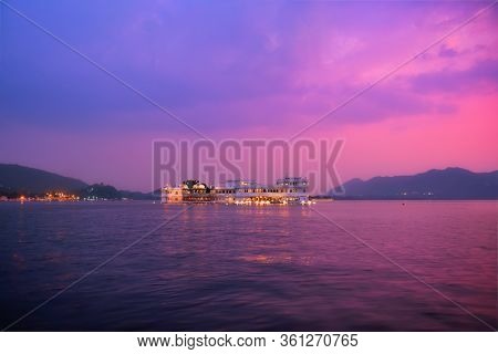 Romantic luxury India travel tourism - Lake Palace (Jag Niwas) complex on Lake Pichola on sunset in twilight with dramatic sky, Udaipur, Rajasthan, India