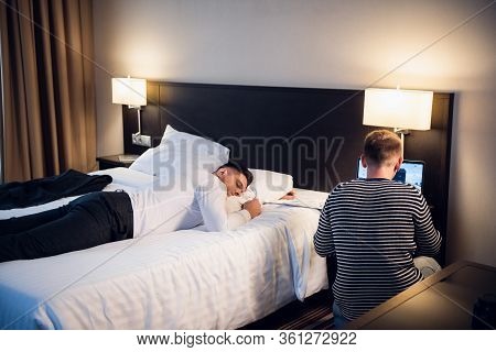 A Computer Hacker Stealing Data From The Businessmans Laptop While He Is Asleep In His Hotel Room. A