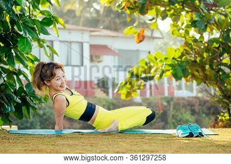 Happy Asian Armless Woman Warming Up Before Swimming At The Tropical Beach