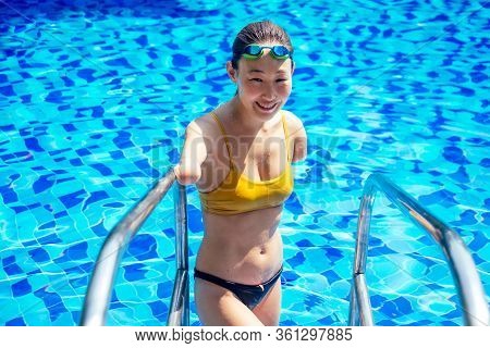 Happy Asian Armless Woman Warming Up Before Swimming At The Tropical Beach, She Jumps