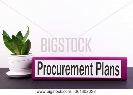 Ring Binder With Inscription Procurement Plans On A Black Table And On A White Background.