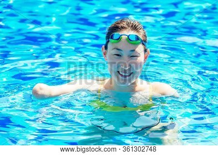Beautiful Young Armless Woman Training To Swim In Pool At Tropical Resort