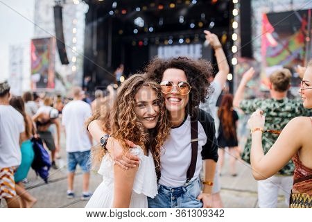 Young Girl Friends At Summer Festival, Posing For Photograph.