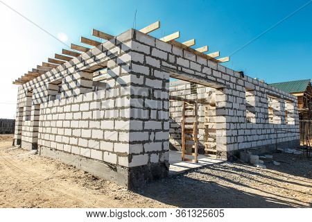 Building Site Of A House Under Construction. Corner Unfinished House Walls Made From White Aerated A