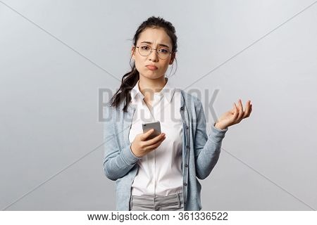 Office Lifestyle, Business And People Concept. Gloomy Indecisive And Puzzled Asian Woman Having Prob
