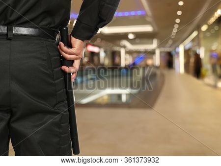Security Guard In Uniform With Police Baton In Shopping Mall, Closeup. Space For Text