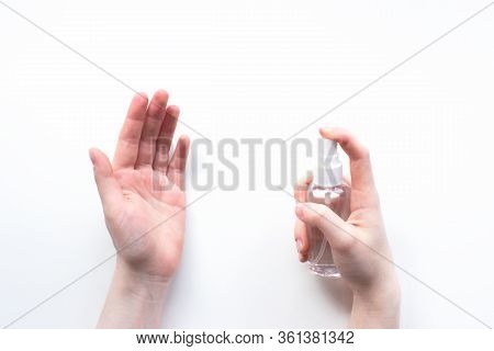 Female Hand Applying Antibacterial Alcohol Spray On White Background Top View. Disinfecting Hands, C