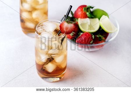 Glasses Of Cold Citrus And Strawberry Ice Tea On Light Gray Background Decorated With Ripe Lime And 