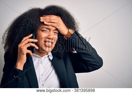 Young african american business woman with afro hair calling using smartphone mobile stressed with hand on head, shocked with shame and surprise face, angry and frustrated. Fear and upset for mistake.