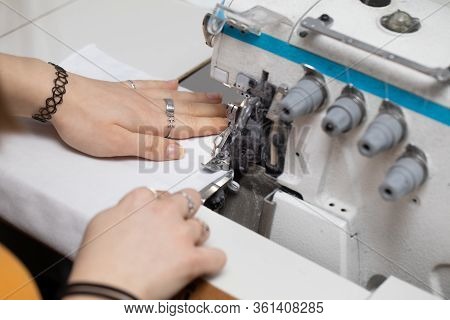 A Young Girl Learns To Sew On A Specialized Sewing Machine.