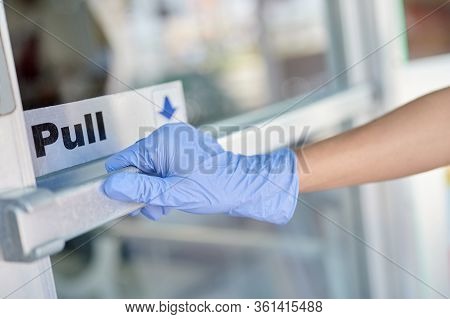 Hand Wearing A Glove Opening Business Door