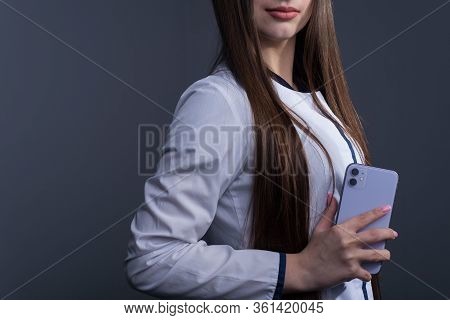 Zaporozhye. Ukraine. February 2020. Studio Portrait Of A Girl In A White Coat. The Doctor Holds In H