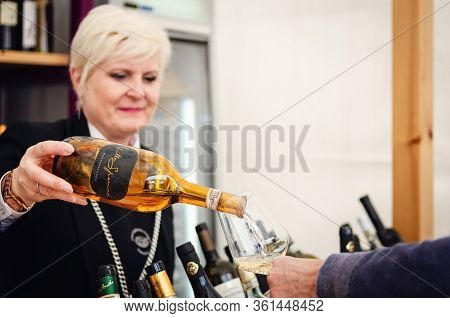 Alba, Italy - April 25, 2019 - Female Sommelier Serving Traditional White Wines Of Piedmont At Vinum