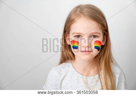 Small Girl With Blond Hair And Painted Cheeks A Rainbow. Stay Home. Flashmob Chasetherainbow.