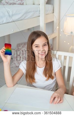 Teen Girl Drawing With A Sponge On A White Sheet Rainbow. Flashmob Chasetherainbow. Stay At Home.