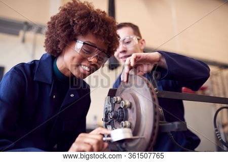 Male And Female Students Working On Car Brakes On Auto Mechanic Apprenticeship Course At College