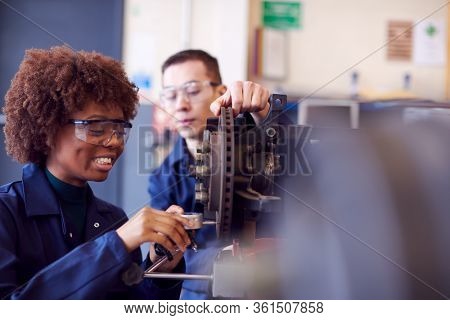 Male And Female Students Working On Car Brakes On Auto Mechanic Apprenticeship Course At College