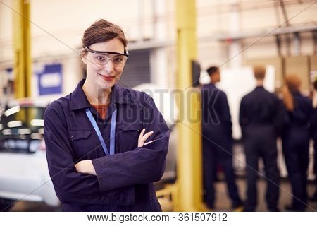 Portrait Of Female Student With Safety Glasses Studying For Auto Mechanic Apprenticeship At College