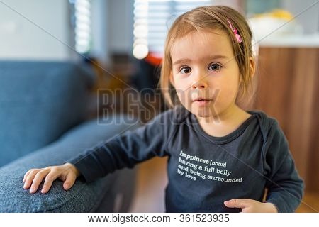Two Year Old Girl With Big Eyas Portrait Looking Towards Camera Natural Light. Selective Focus