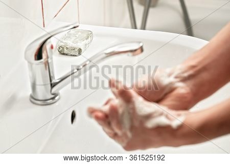 Young Man Washing Hands Under Tap Water With Soap, Focus On Soapbar In Background - Importance Of Us