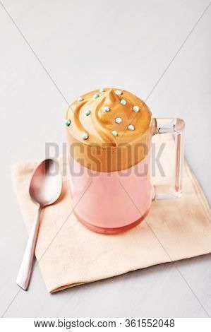 Pink Milk Dalgona Coffee Decorated With Blue Easter Sprinkles In A Glass Cup At Bright Grey Backgrou