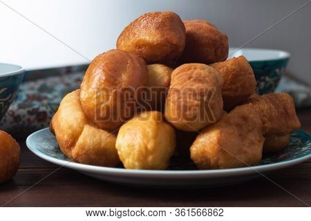 National Cuisine - Uzbek Baursaki In A Plate With A Traditional Pattern, On A Dark Wooden Table. Bas
