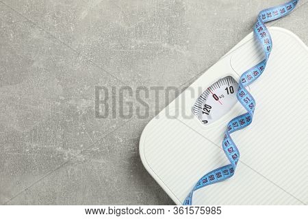 Scales And Measuring Tape On Gray Background. Weight Loss Concept