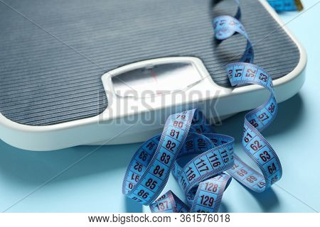 Scales And Measuring Tape On Blue Background. Weight Loss Concept