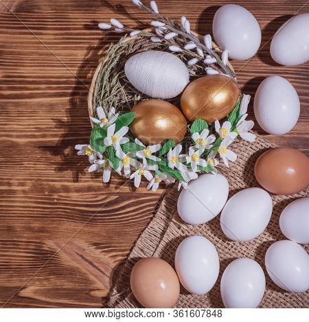 Easter Eggs In Basket Filled With Straw And Yellow Flowers And Willow On Wooden Rustic Vintage Backg