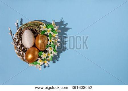 Easter Eggs In Basket Filled With Straw And Yellow Flowers And Willow. Preparation For Holiday. East