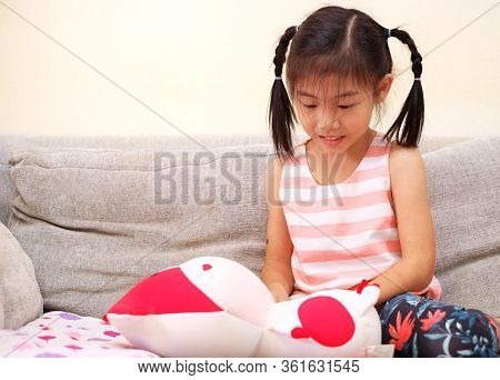 A Young Asian Girl Pretending To Be A Nurse And Taking Care Of Her Stuffed Animal