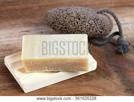 Bar Of Soap And On Wooden Pad And Pumice Stone In Rustic Style. Handmade Olive Oil  Soap And Pumice 
