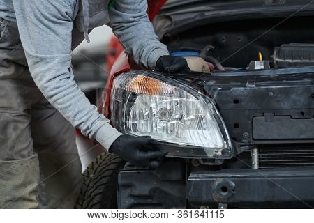 Auto service. Technician assembling an automobile headlight lamp. bodywork repair for insurance