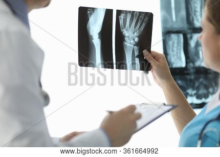 Close-up Of Female Hand Holding Skiagram. Doctor Talking About Diagnosis Of Injured Patient. Surgeon