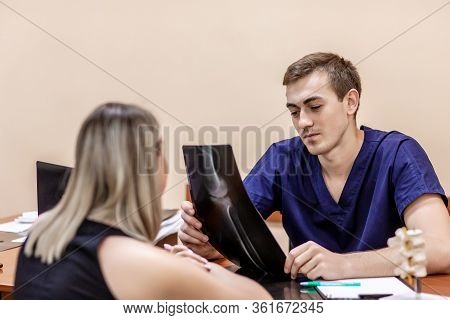 Consultation Of Traumatologist. Portrait Of Doctor Examining Radiogram Picture. Smiling Physician Pl